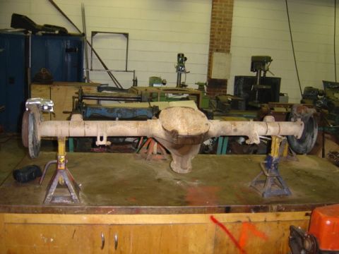 1996 Ford Bronco - A rear axle assembly, likely from a truck or SUV, is shown on jack stands in a workshop.