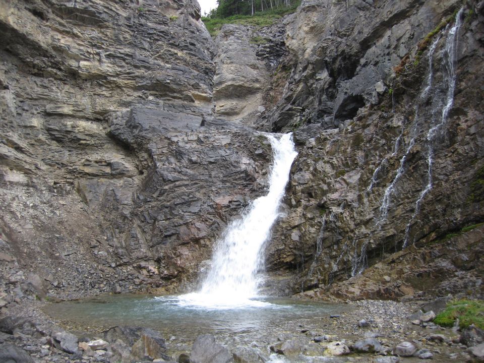 Waterfall cascading down a rocky cliff into a pool.