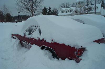 1991 Ford Crown Victoria LTD - A red 1991 Ford Crown Victoria LTD is almost completely covered by a thick blanket of snow.