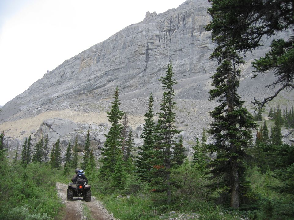 ATV on a dirt path with a mountain backdrop