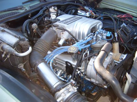 1973 Ford Ranchero - A close-up view of a Ford 5.0 HO engine, showing the intake manifold, distributor, spark plug wires, and air intake system.