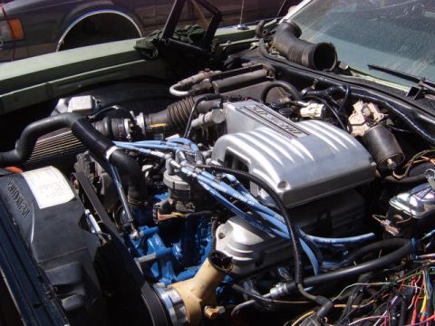 1973 Ford Ranchero - Close-up view of a V8 engine bay, likely from a classic American muscle car, showing the intake manifold, spark plug wires, and various hos…