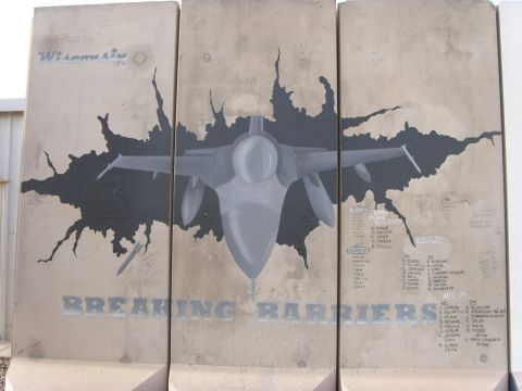 1978 Ford Bronco - Mural on concrete barriers shows a jet breaking through a wall, with 'BREAKING BARRIERS' text and names.