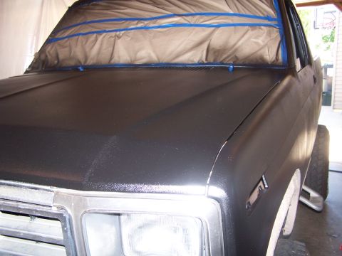 1986 Ford Bronco - A vehicle is being prepped for a new paint job, with the front end covered for protection.