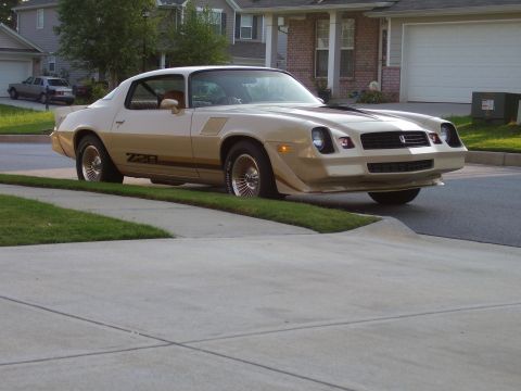 1979 Chevrolet Camaro - A two-tone tan Chevrolet Camaro Z28 is parked on the side of a suburban street.