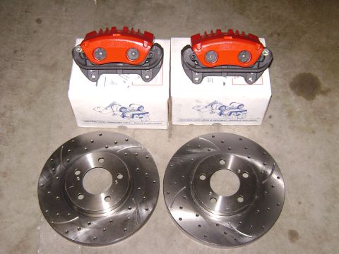 1991 Ford Taurus - Pair of red brake calipers and drilled rotors are displayed on white boxes, with a "Supermotors.net" watermark visible.