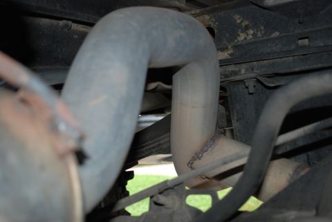 1994 Ford Bronco - Close-up view of the exhaust system and undercarriage of a vehicle.