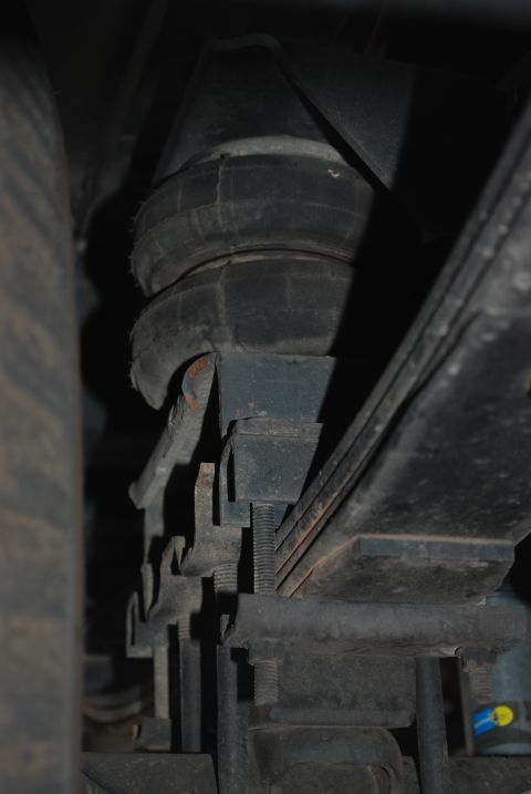 1994 Ford Bronco - Air suspension bellows and leaf spring assembly visible on a vehicle's undercarriage.