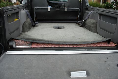 1994 Ford Bronco - Interior view of a 1994 Ford Bronco cargo area, with carpet lifted to reveal insulation.