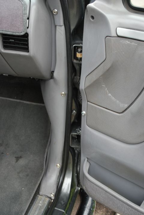 1994 Ford Bronco - Close-up view of the interior door jamb and dashboard area of a vehicle.