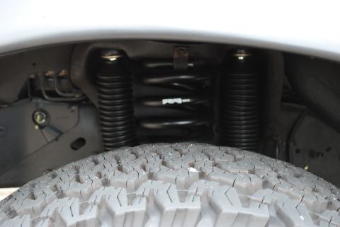 1994 Ford Bronco - The image shows the front tire and suspension system of a vehicle, including shocks and coil springs.