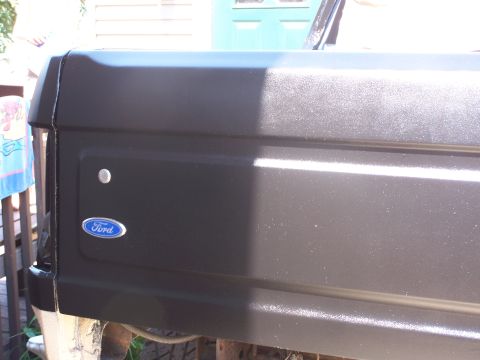 1986 Ford Bronco - Close-up of the rear side panel of a Ford Bronco, showing the iconic Ford emblem.