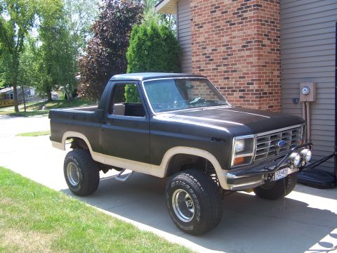 1986 Ford Bronco - This lifted Ford Bronco features a two-tone paint scheme and off-road lights.