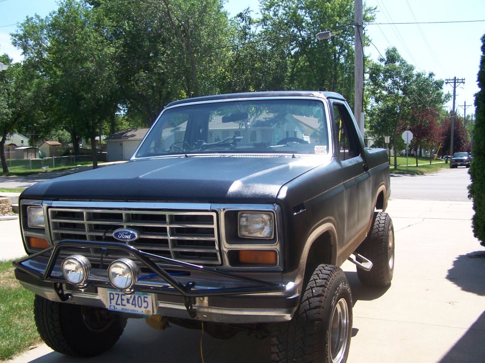 1986 Ford Bronco with aftermarket bumper and lights, lifted suspension