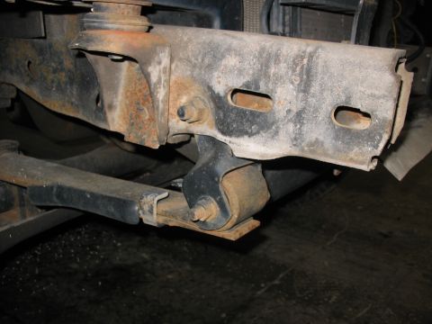 1995 Ford C-350 (Centurion Conversions) - Close-up view of heavily rusted frame components, showing bolts and suspension parts.