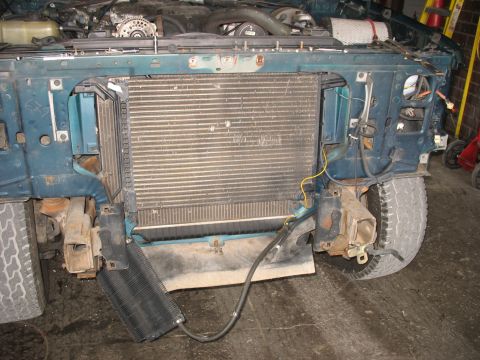 1995 Ford C-350 (Centurion Conversions) - The front end of a truck is disassembled, revealing the radiator and engine components.