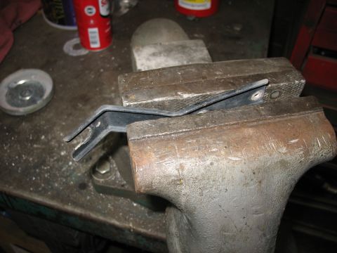 1995 Ford C-350 (Centurion Conversions) - A metal bracket is secured in a vise, likely for modification or repair.