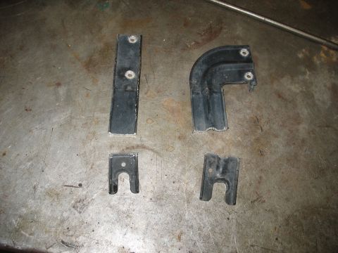 1995 Ford C-350 (Centurion Conversions) - Several automotive brackets are shown on a workbench, possibly for an intercooler installation.