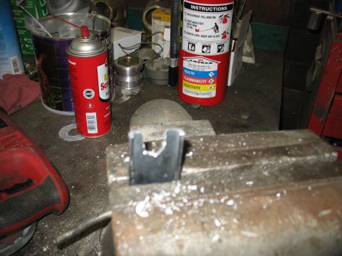 1995 Ford C-350 (Centurion Conversions) - Metal part being worked on in a vise, surrounded by workshop tools and supplies.