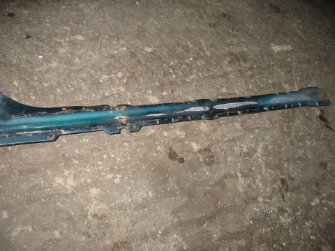1995 Ford C-350 (Centurion Conversions) - A detached teal metal trim piece shows significant wear and tear, including rust and chipped paint.