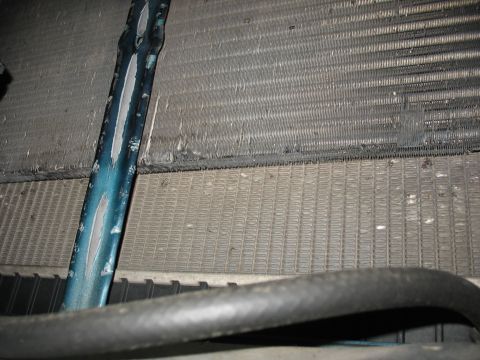 1995 Ford C-350 (Centurion Conversions) - Damaged intercooler and radiator assembly with a bent pipe, suggesting a need for repair or replacement.