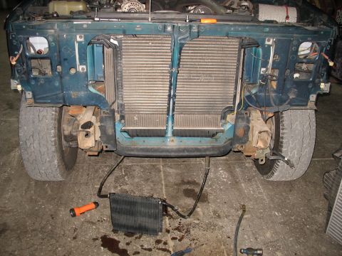 1995 Ford C-350 (Centurion Conversions) - Intercooler removed from the front of a teal truck, with the radiator and engine components exposed.