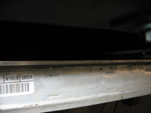 1995 Ford C-350 (Centurion Conversions) - Close-up of a metal bracket with a label and barcode, likely a part number or identification tag.