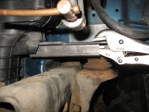1995 Ford C-350 (Centurion Conversions) - Close-up of a metal bracket being secured with vise grips, part of an intercooler installation.