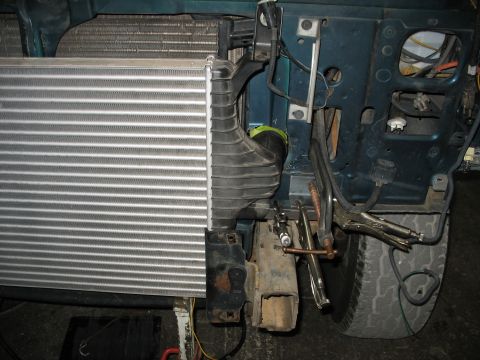 1995 Ford C-350 (Centurion Conversions) - Close-up view of an intercooler being installed on the front of a vehicle.