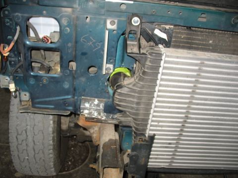1995 Ford C-350 (Centurion Conversions) - Close-up view of intercooler and associated ducting within the engine bay of a vehicle.