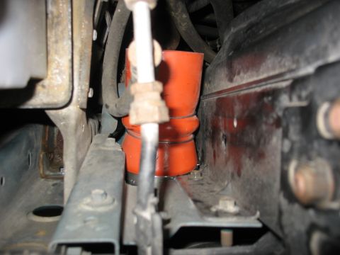 1995 Ford C-350 (Centurion Conversions) - Close-up view of engine bay components, including an orange intercooler hose and metal brackets.