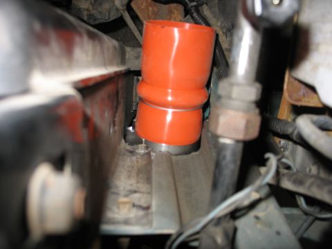 1995 Ford C-350 (Centurion Conversions) - Close-up view of an orange intercooler hose being installed in a vehicle's engine bay.