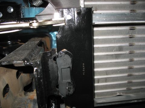 1995 Ford C-350 (Centurion Conversions) - Detail of a radiator and its mounting hardware, showing a black bracket with a connector.