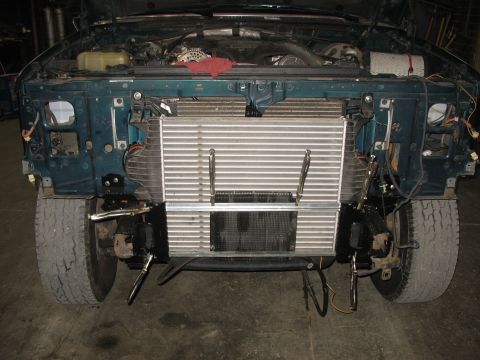 1995 Ford C-350 (Centurion Conversions) - The front of a truck is disassembled, revealing the engine and a newly installed intercooler.