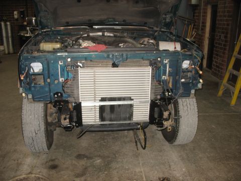 1995 Ford C-350 (Centurion Conversions) - Front end of a teal truck with the hood open, revealing the intercooler and engine bay during a repair or modification.