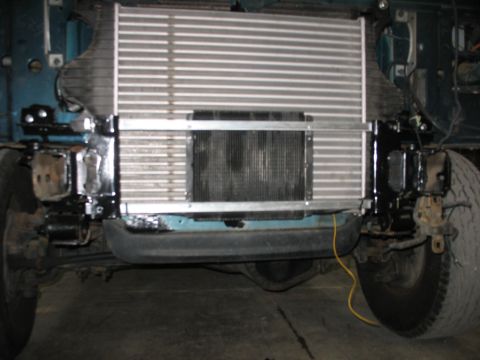 1995 Ford C-350 (Centurion Conversions) - Intercooler and radiator assembly installed on a vehicle, showing front suspension and tires.