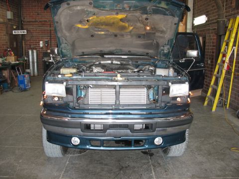 1995 Ford C-350 (Centurion Conversions) - Front view of a green 1995 Ford C-350 (Centurion Conversions) with its hood open, revealing the intercooler installation.