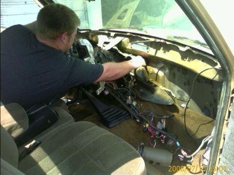 1990 Ford Bronco - man reaches into the gutted dashboard and exposed wiring of a truck cab during a restoration, with a 2008/07/26 date stamp.