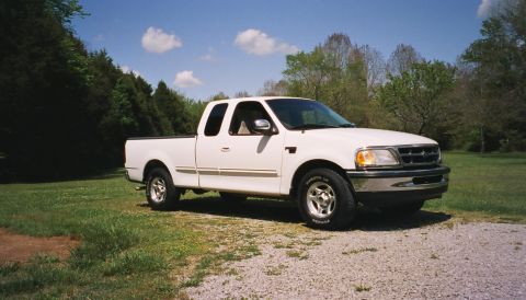 2007 Ford Mustang - This white 1997 Ford F-150 SuperCab pickup truck is parked on a gravel surface.