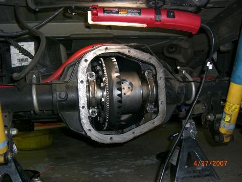 2007 Ford Mustang - Close-up of a vehicle's differential housing and gears, with a work light and jack stands visible.