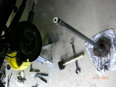 2007 Ford Mustang - Axle shaft and brake components laid out on a concrete floor with tools nearby. A date stamp shows 3/31/2007.