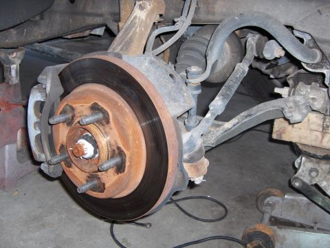 2007 Ford Mustang - Close-up of a vehicle's front wheel hub and brake assembly, showing suspension parts.