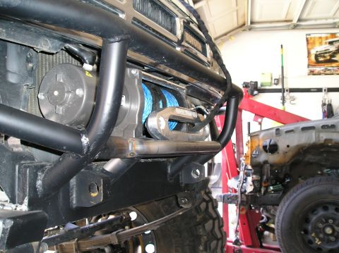 1986 Toyota Hilux - A close-up of a modified truck bumper shows a winch and "TOYOTA" badging, with another vehicle in the background.