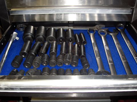 2007 Ford Mustang - A variety of sockets and wrenches are neatly organized in a metal tool drawer on a blue mat.