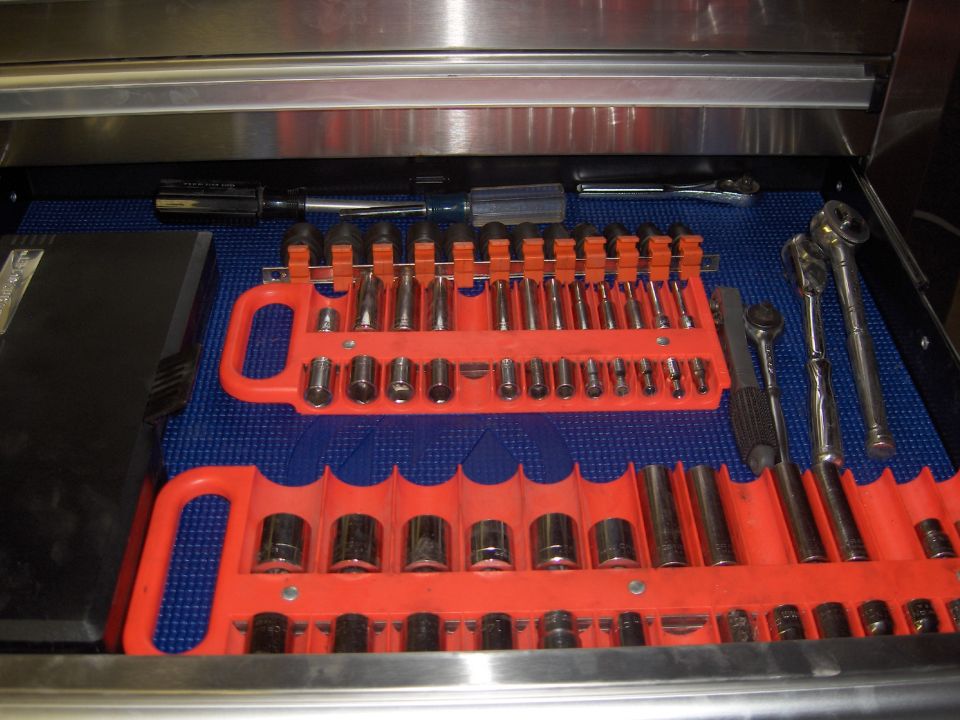 Tool drawer with two orange socket organizers holding various sockets and ratchets on a blue mat