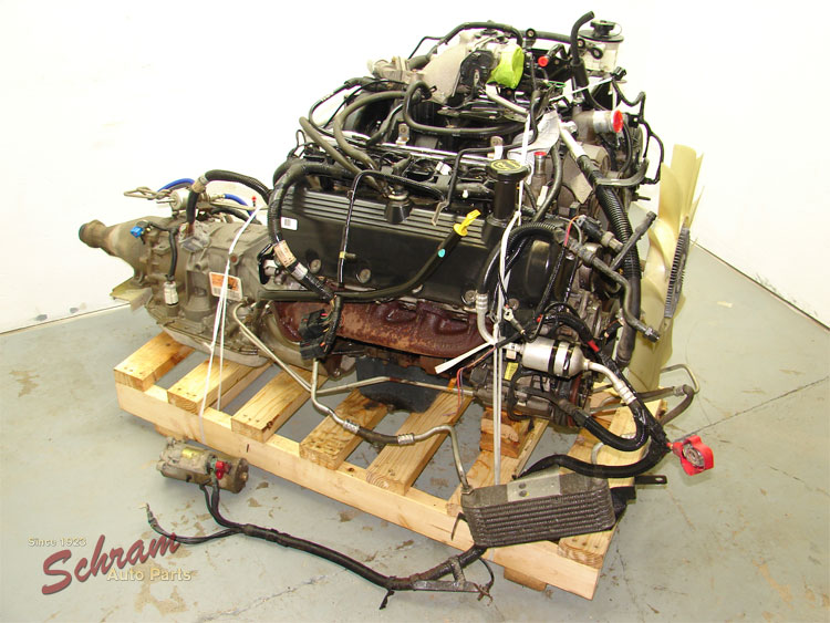 Engine and transmission on a wooden pallet. Some hoses and wires are attached