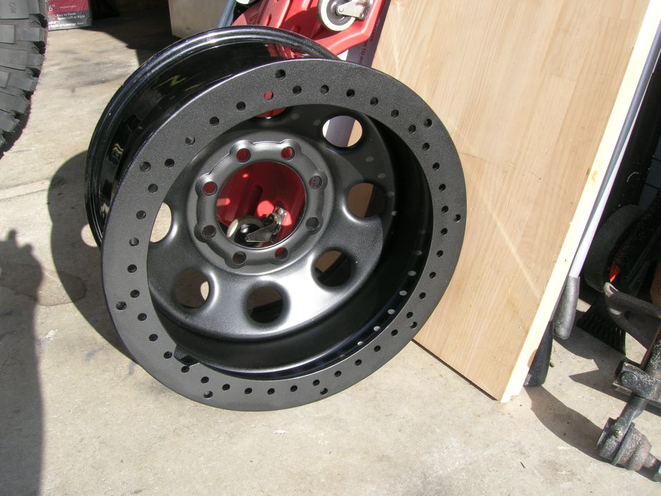 Black aftermarket wheel with faux beadlock ring and red inner barrel