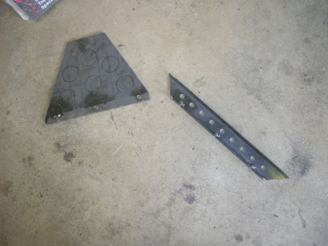 1996 Ford Bronco - Two custom metal parts are laid out on a concrete surface, possibly for fabrication or assembly.