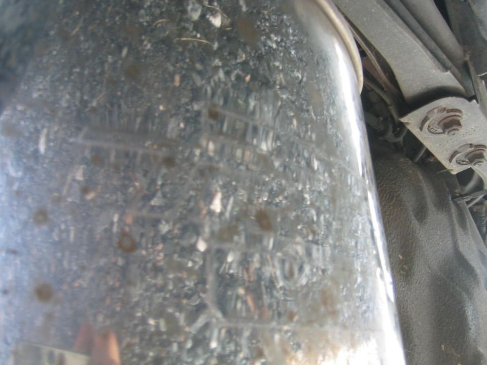 close-up of a dirty exhaust pipe with some markings on it