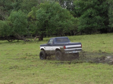 1993 Ford Bronco - Ford Bronco navigates a muddy field, showing off its off-road capabilities.